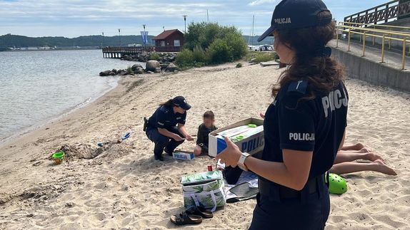 policjantka na plaży rozmawia z dzieckiem o bezpieczeństwie