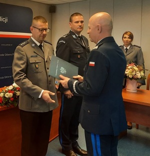 Komendant Główny Policji składa gratulacje starszemu aspirantowi Rafałowi Zduniakowi obok którego stoi Komendant Miejski Policji w Łodzi inspektor Dariusz Dziurka