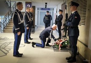 kierownictwo polskiej Policji przed tablica pamięci w trakcie składania kwiatów
