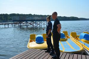 policjanci stoją na pomoście przy akwenie