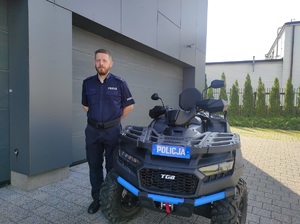 policjant stoi przy quadzie
