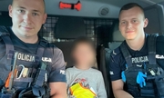 na zdjęciu dwójka policjantów z chłopcem siedzą w radiowozie