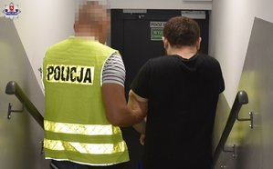 policjant prowadzi zatrzymanego mężczyznę