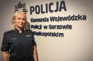 na zdjęciu mł. asp. Magdalena Kleist stoi przy ścianie z napisem Policja, Komenda Wojewódzka Policji w Gorzowie Wielkopolskim