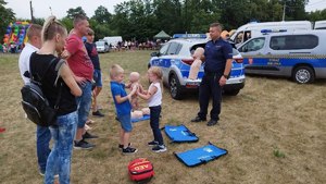 Policjant prezentuje zasady pierwszej pomocy.