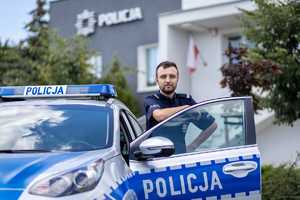 St. sierż. Dominik Napierała przed Komisariatem Policji w Puszczykowie, przy radiowozie