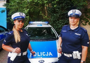 na zdjęciu dwie umundurowane policjantki, w tle radiowóz