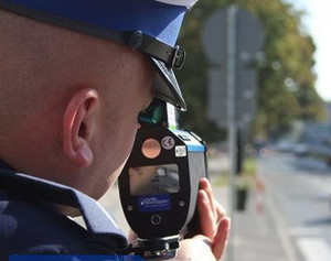 Policjant mierzący prędkość laserowym miernikiem prędkości