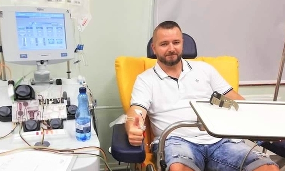 Zdjęcie przedstawia policjanta, który oddaje krew, a także odznakę koloru brązowego oraz niebieską legitymację