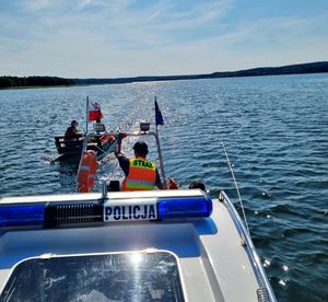 policjanci holują łodzią policyjna katamaran