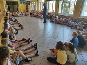 Policjant rozmawia z dziećmi i ich opiekunem.
