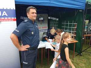 Policjanci z dziećmi obok namiotu profilaktycznego Policji.