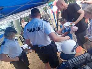 Policjanci i uczestnicy pikniku w namiocie profilaktycznym Policji.