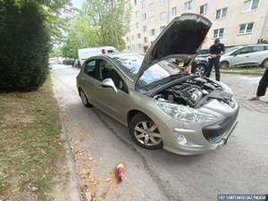 samochód z otwartą maską, obok niego policjant