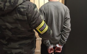 policjant z zatrzymanym mężczyzną