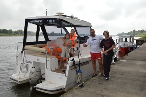 uratowani turyści stoją przy łodzi