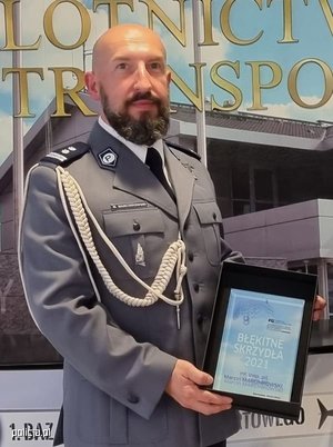 Naczelnik Wydziału z Zarządu Lotnictwa polskiej Policji prezentuje otrzymaną nagrodę.
