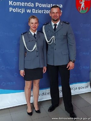 policjant i policjantka pozują do zdjęcia