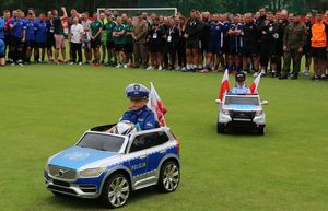 chłopiec w policyjnym stroju jedzie małym, policyjnym radiowozem podczas rozpoczęcia Euro Cup turnieju piłki nożnej im. st. sierż. Marcina Szpyruka