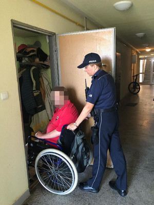 Policjantka pomaga mężczyźnie na wózku inwalidzkim