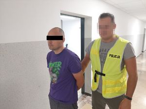 policjant prowadzi zatrzymanego  mężczyznę