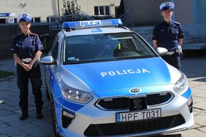 umundurowani policjanci stoją przy radiowozie