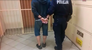 policjant prowadzi zatrzymanego mężczyznę