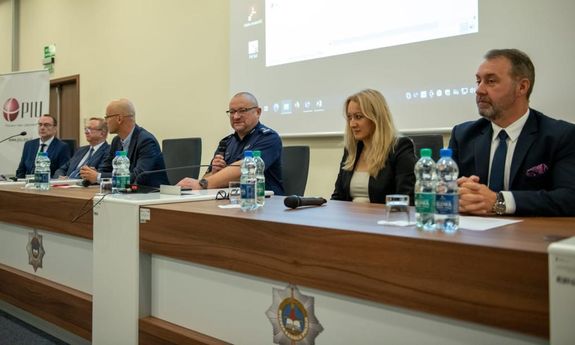 seminarium szkoleniowe, wykładający siedzą za stołem prezydialnym
