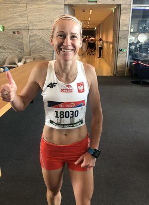 uśmiechnięta zawodniczka  w stroju sportowym we wnętrzu budynku