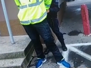 policjantka trzyma zatrzymanego mężczyznę