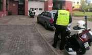 stojące przed szpitalem dwa motocykle policyjne i umundurowany policjant