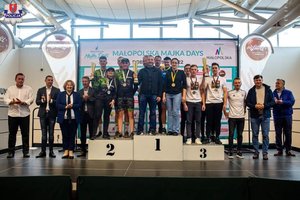 Zdjęcie grupowe, podium na którym stoją  uczestnicy wyścigu kolarskiego