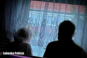 Para seniorów patrzy przez okno mieszkania