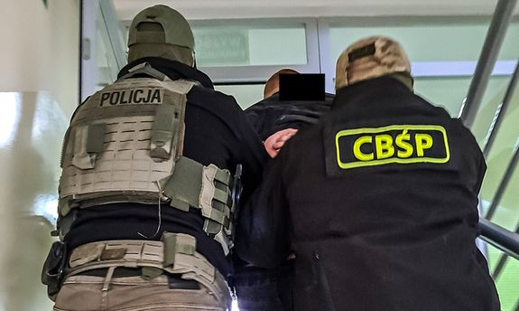 policjanci prowadzą zatrzymanego