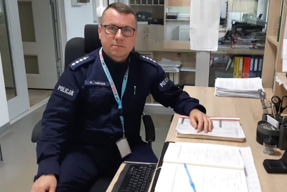 &quot;asp. szt. Krzysztof Zaręba siedzący za biurkiem