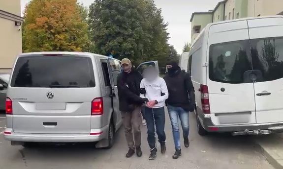 policjanci prowadzą zatrzymanego mężczyznę