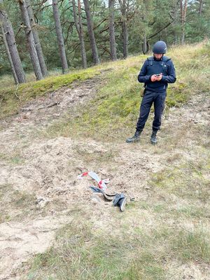 policjant na poligonie przed nim z ziemi wystaje but i kawałek nogawki spodni