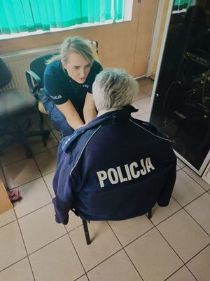 Policjantka rozmawia z seniorką. Seniorka ma założona bluzę z napisem Policja