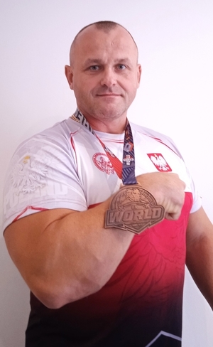 aspirant sztabowy Dariusz Popiołek pozuje do zdjęcia z medalem