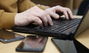 na zdjęciu widać ręce osoby piszącej na klawiaturze laptopa