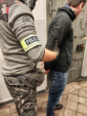 policjant prowadzi zatrzymanego