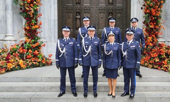 grupa umundurowanych polskich policjantów pozuje do zdjęcia na schodach prowadzących do budynku