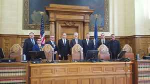 mężczyźni w garniturach i kobieta pozują do zdjęcia w jednej z amerykańskich instytucji