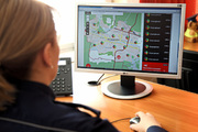 policjantka siedzi przed ekranem monitora komputera na którym widać Krajową Mapę Zagrożeń Bezpieczeństwa