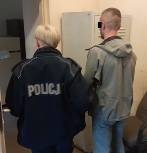 Policjantka prowadzi zatrzymanego mężczyznę