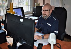 policjant dyżurny siedzi przy biurku