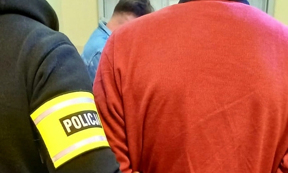 policjant prowadzi zatrzymanego mężczyznę