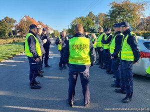 grupa umundurowanych policjantów w żółtych kamizelkach biorąca udział w poszukiwaniach