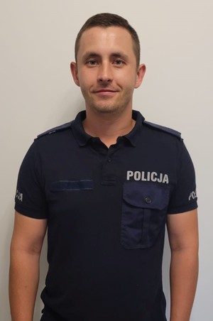 umundurowany policjant pozuje do zdjęcia