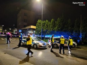 pora nocna - zatrzymane auto i policyjne radiowozy a przed nimi policjanci